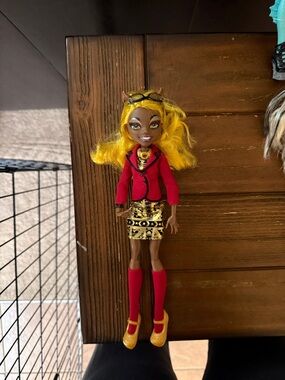 monster high yellow-haired doll with red jacket and gold skirt